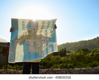 Shadow of boy holding up a map, Majorca, Spain