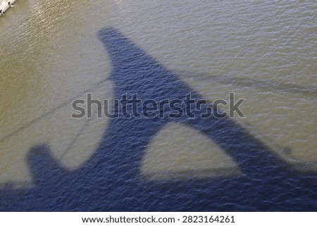 Shadow of a bridge on the surface of the river