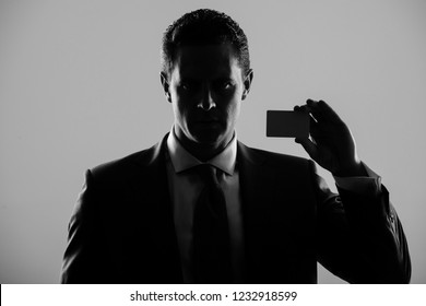 Shadow Business, Businessman, Man Or Manager Holding Bank Or Business Card In Blue Formal Suit And Tie On Grey Background. Banking, Fraud, Skimming, Ecash And Information