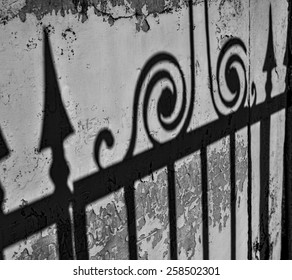 The Shadow Of An Elaborate Wrought Iron Fence On An Old Wall In New Orleans.