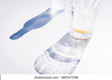 Shadow Of A Glass With Ice And Lemon Next To The Shadow Of A Bottle With Hard Light.