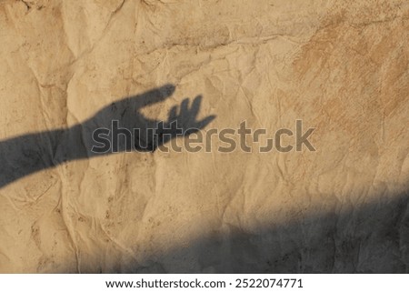 the shadow of a hand reaching out