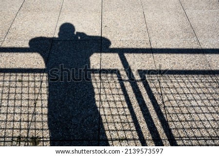 The shadow of a human figure on a stone pavement