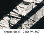 Shadow and light pattern on crumpled cotton bedsheet, top view