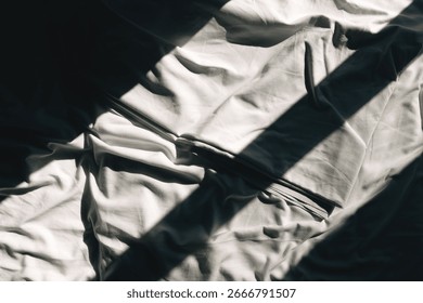 Shadow and light pattern on crumpled cotton bedsheet, top view