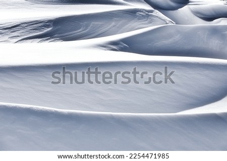 Shadow and light in snowdrifts in white winter snow