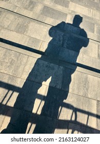 The shadow of a man fell on the concrete steps, the shadow created an abstract and unusual image of a human silhouette, a natural optical effect