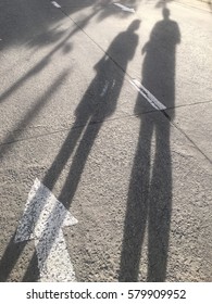 Shadow man and girl on street