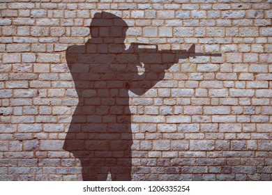 Shadow Of A Man With A Gun On The Wall.