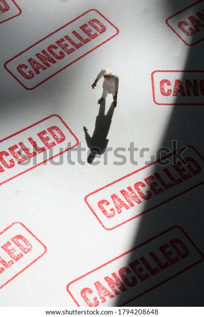 Shadow man on cancelled stamp\
background. Cancel culture concept with miniature, anonymous\
person.  Person is labelled via social media or the\
internet.
