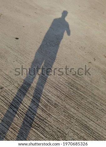 The shadow of a man on the concrete floor