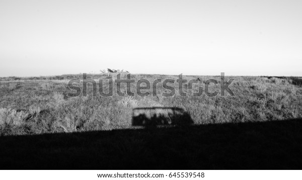 Shadow of minibus in black and white\
style, when you travel to Khaokho phetchabun Thailand, you can buy\
a ticket for travel around wind turbine\
field.