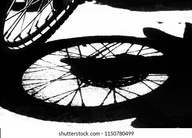 shadow of motorbike wheel parking on concrete road background, closed up,  black and white artwork concept