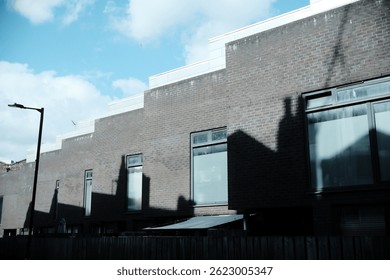 shadow on the side of a building captured with artistic lighting and excellent composition. the scene features under moody and dramatic conditions.