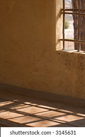 Shadow patterns of bamboo window lattice on wooden bench