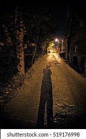 Shadow Of A Person In A Dark Urban Alley At Night