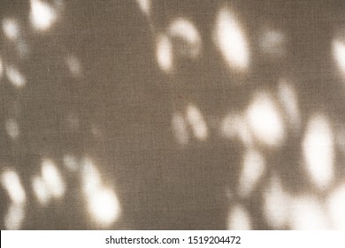 The shadow of the plant shines through the fabric. Linen fabric texture. Natural mood with shadow and light