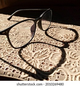 Shadow Of Progressive Lens Black Frame Glasses On Patterned Tablecloth