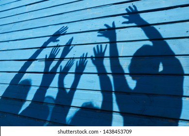 Shadow Silhouette Of Happy Young People Having Fun In Summer On Blue Wood Background, Copy Space