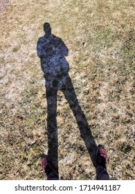 Shadow Of A Tall Man On The Ground Texture. A Person's Shadow On A Lawn 