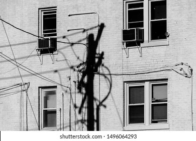 Shadow Of Telephone Pole With Multiple Wires Against White Building