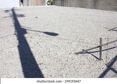 Shadow Of A Telephone Pole Reflected On The Vacant Lot