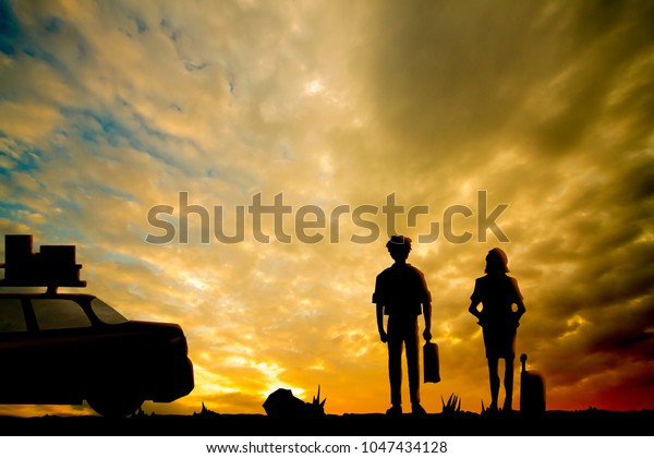 Shadow of travel trip on evening man and girl\
stand on the grass with car have picnic on top roof.Evening gold\
sky for background.