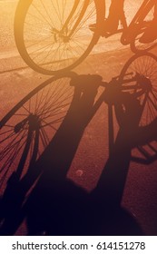 Shadow Of Unrecognizable Cyclist Riding A Bike On Road Through City Street In Urban Surrounding, Retro Toned