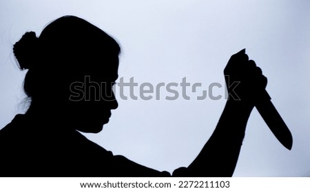 Shadow of a woman with knife in hand with suspicious activity or going to stab someone to death.