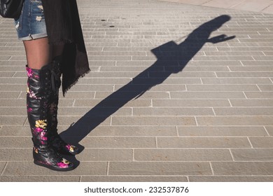 Shadow Of A Young Woman Wearing Over The Knee Boots And Working On Her Tablet