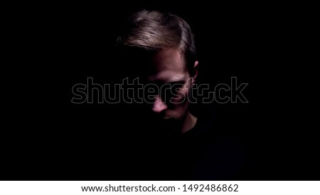 Shadowed man looking down, maniac preparing for cruel murder, criminal