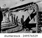 Shadows of 6th Division Marines on a battle-wrecked tank on Okinawa. The soldiers are advancing to mop up operations in the southern tip of the island. Late May to early June 1945.