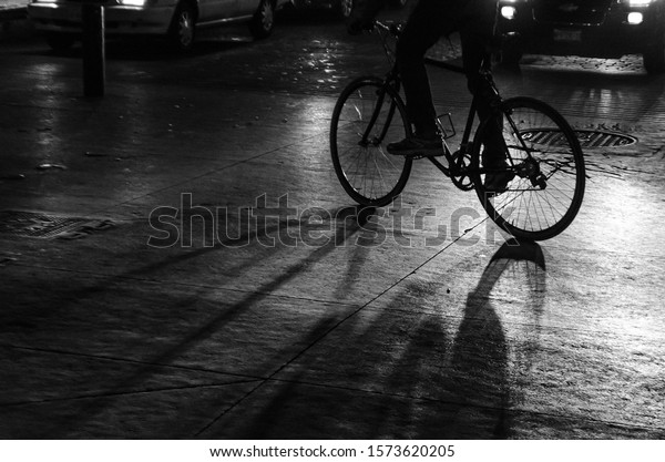 shadows of a bike and\
its driver at night