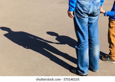 Shadows of father and son holding hands
