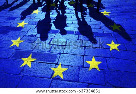 Shadows group of people walking on sunny stone tiled street floor painted with European Union flag.