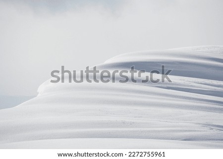 Shadows and light on mountain summit snowdrift 