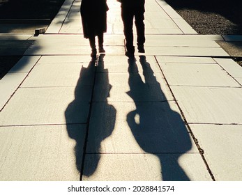 Shadows of men and women walking in the precincts
