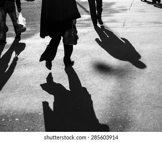 Shadows Of People Walking In A Street In Morning Light