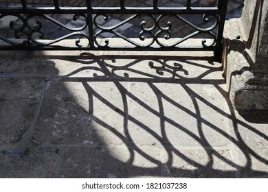 shadows of a railing reflected on the floor of an ancient road in Puglia