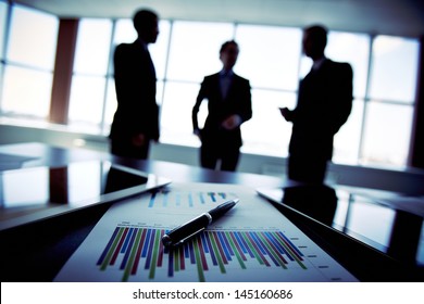 Shadowy business trio holding a briefing concerning the reported statistic data - Shutterstock ID 145160686