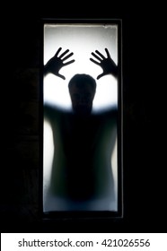 Shadowy figure behind glass.  Dramatic film grain - Shutterstock ID 421026556
