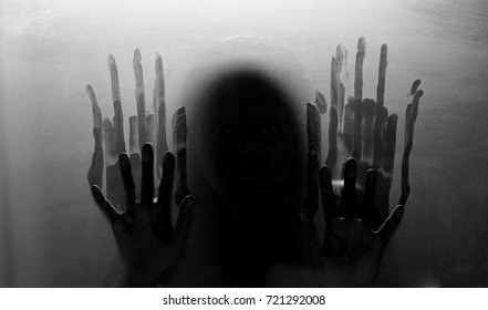 Shadowy figure behind glass. Fear and panic concept. Black and white tone.