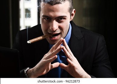 Shady man smoking a cigar in his office