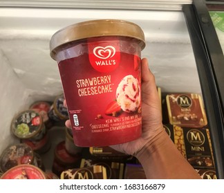 Shah Alam, Malaysia – 10 March 2020: Hand Holding Strawberry Cheesecake Ice Cream From The Chiller Box In The Supermarket. A Product Produced By Wall's. Image May Contain Excessive Noise.