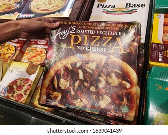 Shah Alam, Malaysia - 26 January 2020 : Hand Hold A Box Of AMY'S Roasted Vegetable Pizza No Cheese For Sell In The Supermarket With Selective Focus.