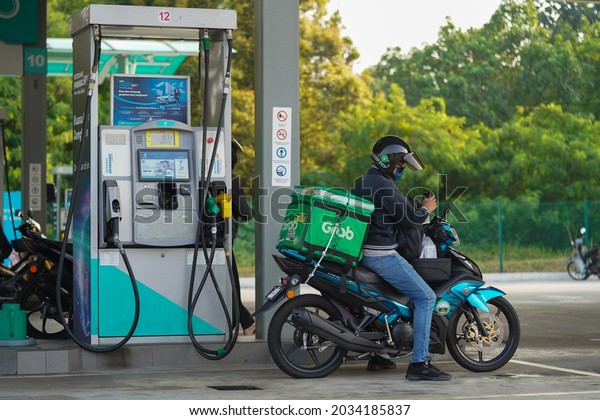 Shah Alam,\
Selangor - September 1, 2021 : Grab rider on motorcycle finish\
refuel at PETRONAS petrol pump\
station