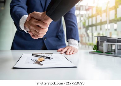 Shake hand Real estate brokerage agent Deliver a sample of a model house to the customer, mortgage loan agreement Making lease and buy and sell house And contract home insurance mortgage loan concept - Shutterstock ID 2197519793