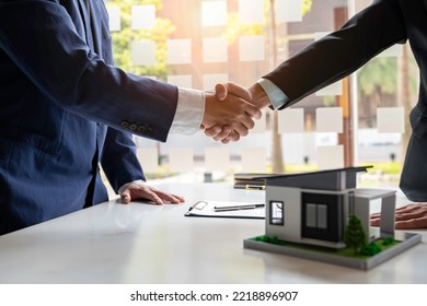 Shake hand Real estate brokerage agent Deliver a sample of a model house to the customer, mortgage loan agreement Making lease and buy and sell house And contract home insurance mortgage loan concept - Shutterstock ID 2218896907
