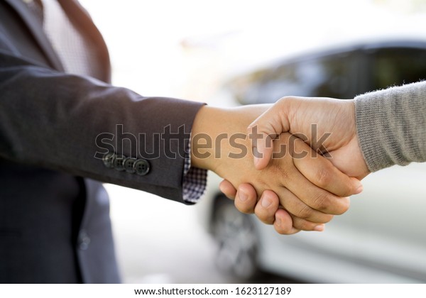 Shake hands, agree to\
buy and sell a car