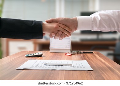 Shakehand Of Lawyer And Business Woman Sitting Behind Desk With Agreement.